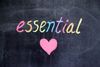 On a blackboard is the handwritten text, “Essential”, and a heart.