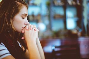 A young woman in deep thought, contemplating.