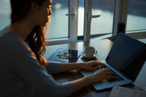 Woman typing on laptop keyboard.