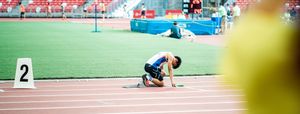 Athlete starting a sprint from the starting blocks on running track.